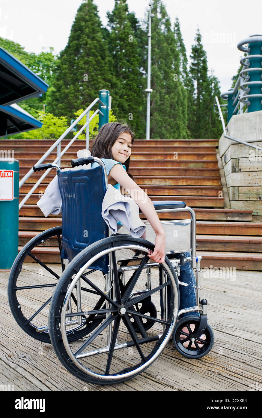Junges Mädchen im Rollstuhl vor Treppen Stockfoto