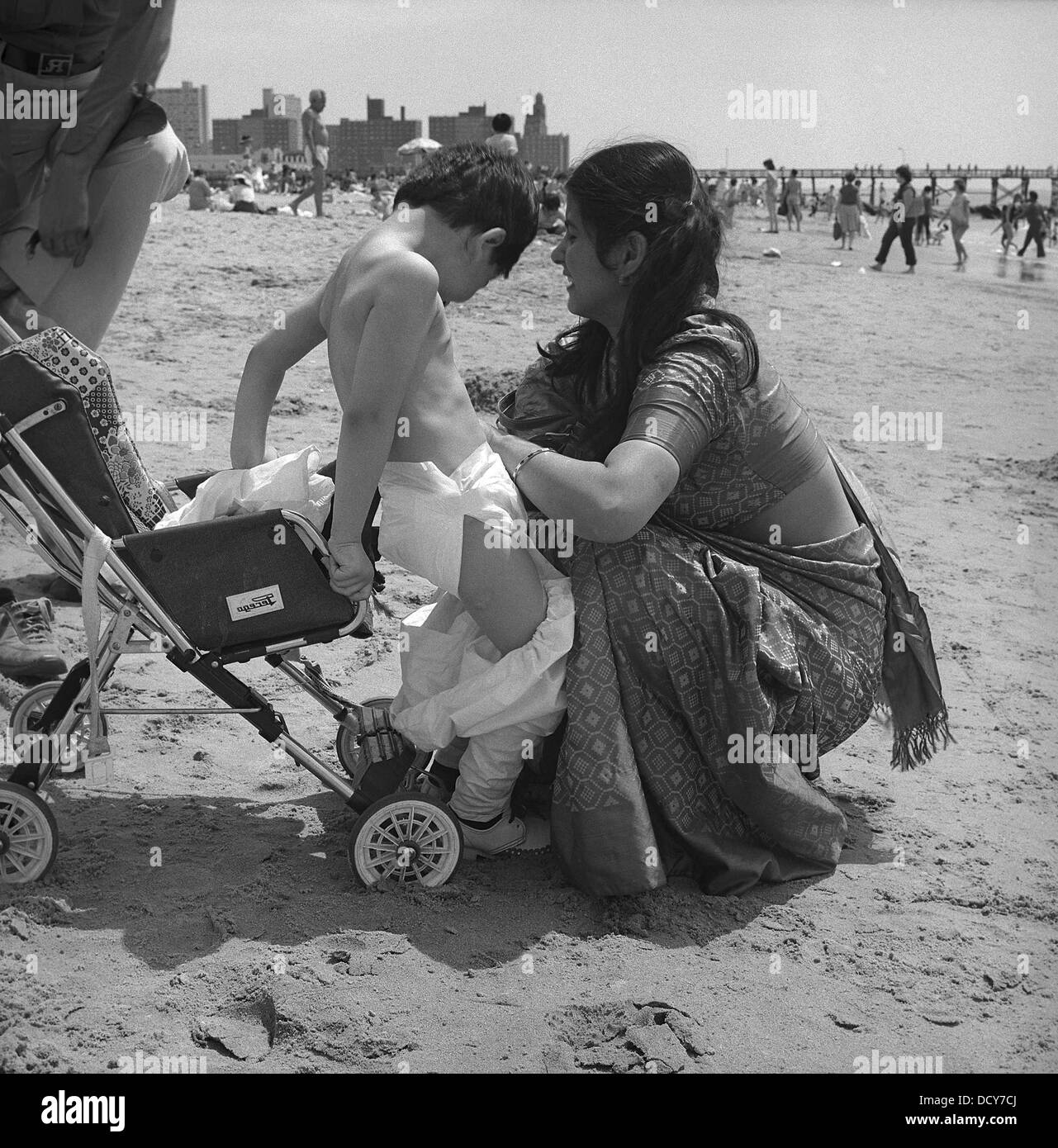 Indische Mutter Windeln ihres Sohnes am Strand von Coney Island  Stockfotografie - Alamy