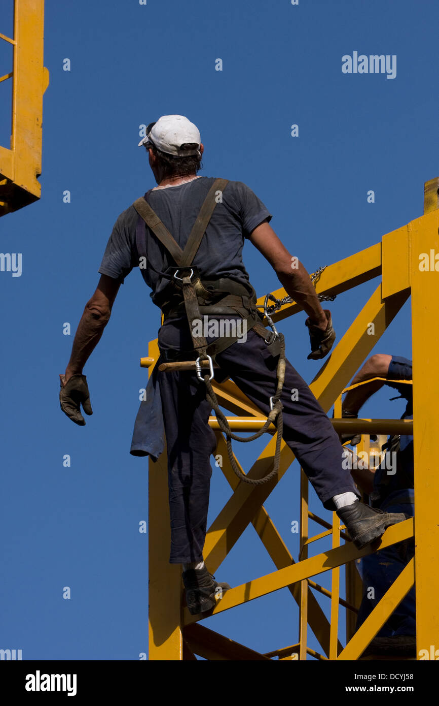 Arbeiter, die darauf warten, neue Stück Kran befestigen Turm wird Overhead schwang Stockfoto