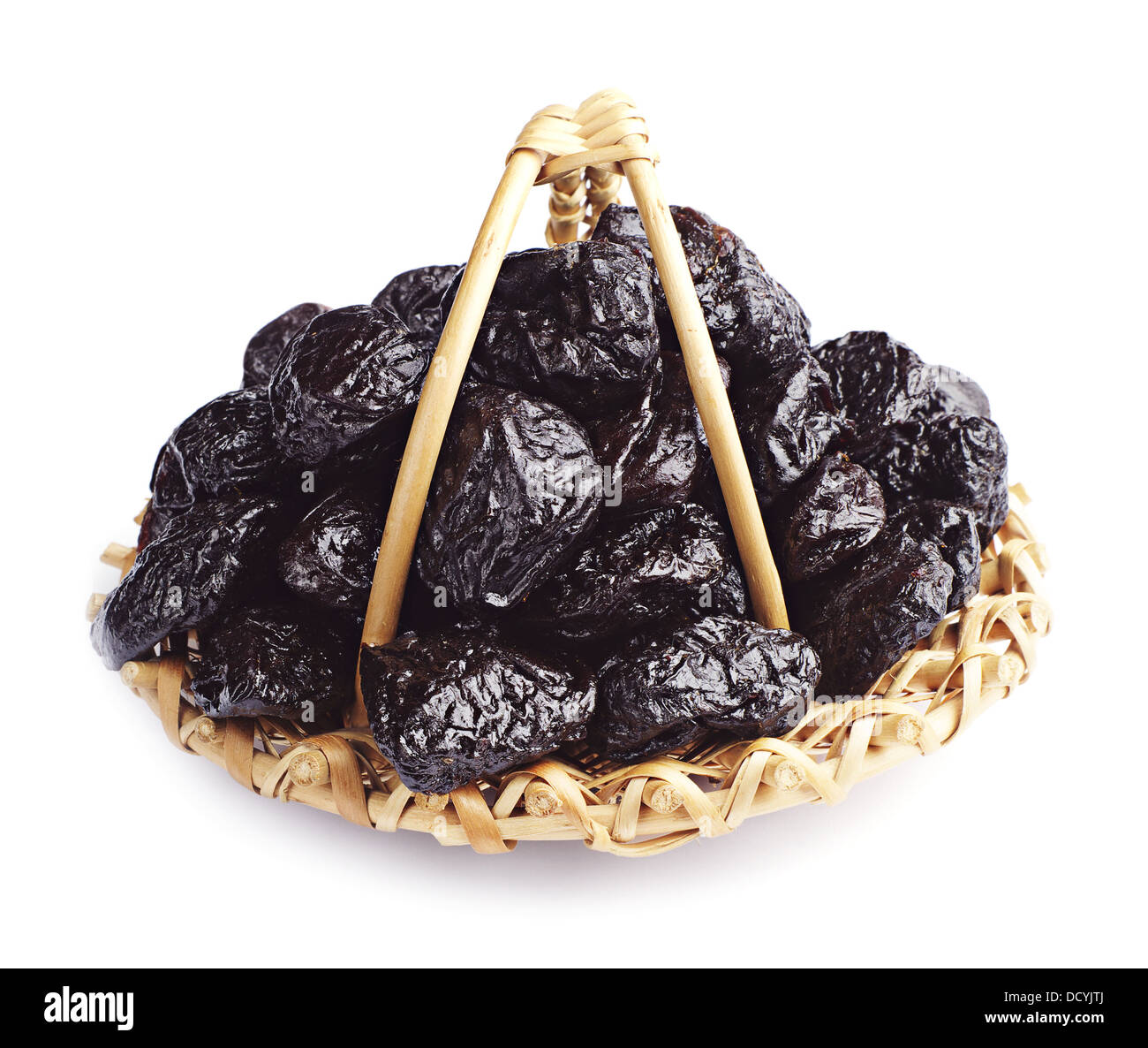 Getrocknete Pflaumen in einem Weidenkorb auf weiß Stockfoto