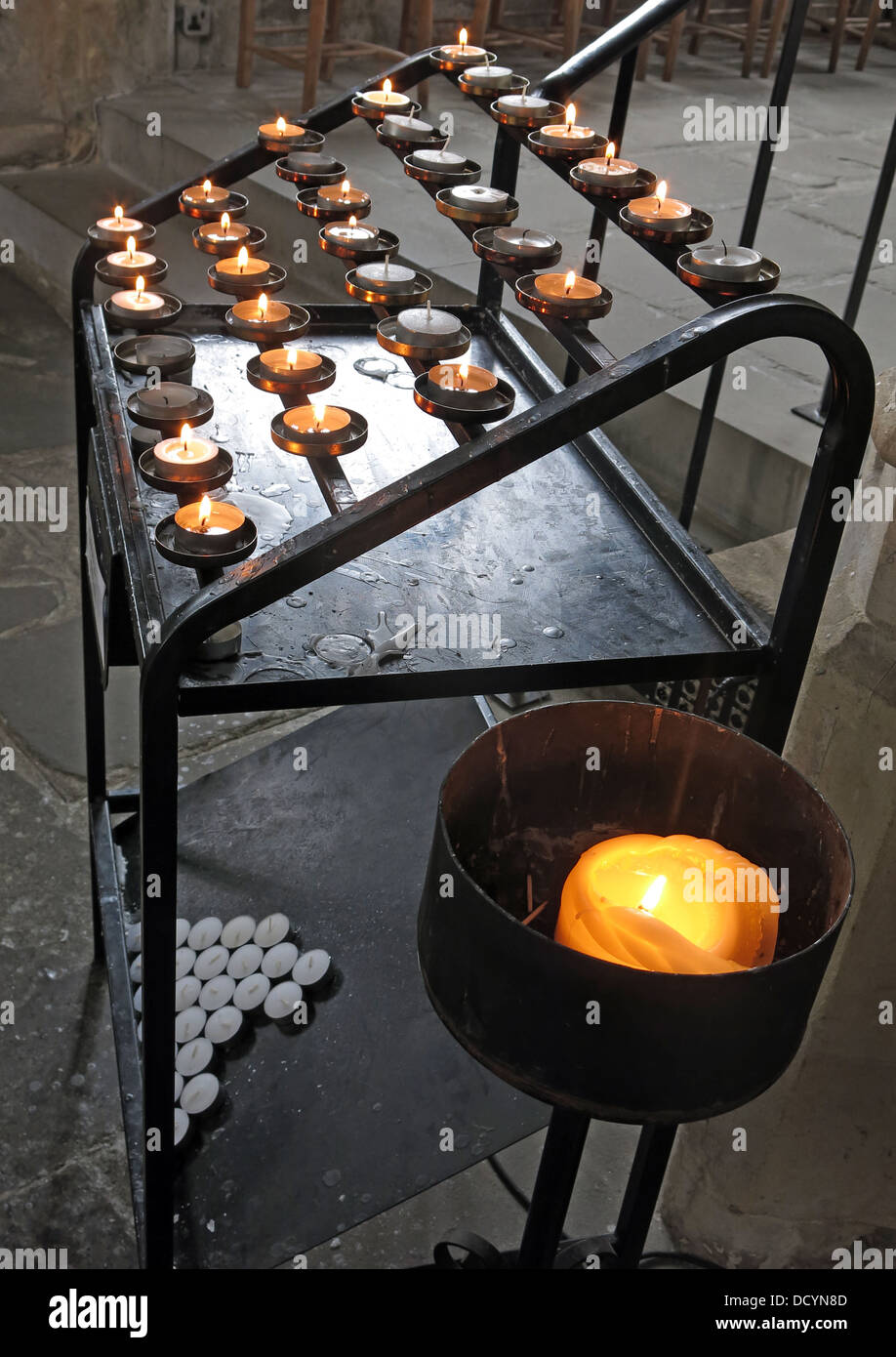 Opferkerzen - eine Kerze, ein Gebet, in einer Kirche Stockfoto