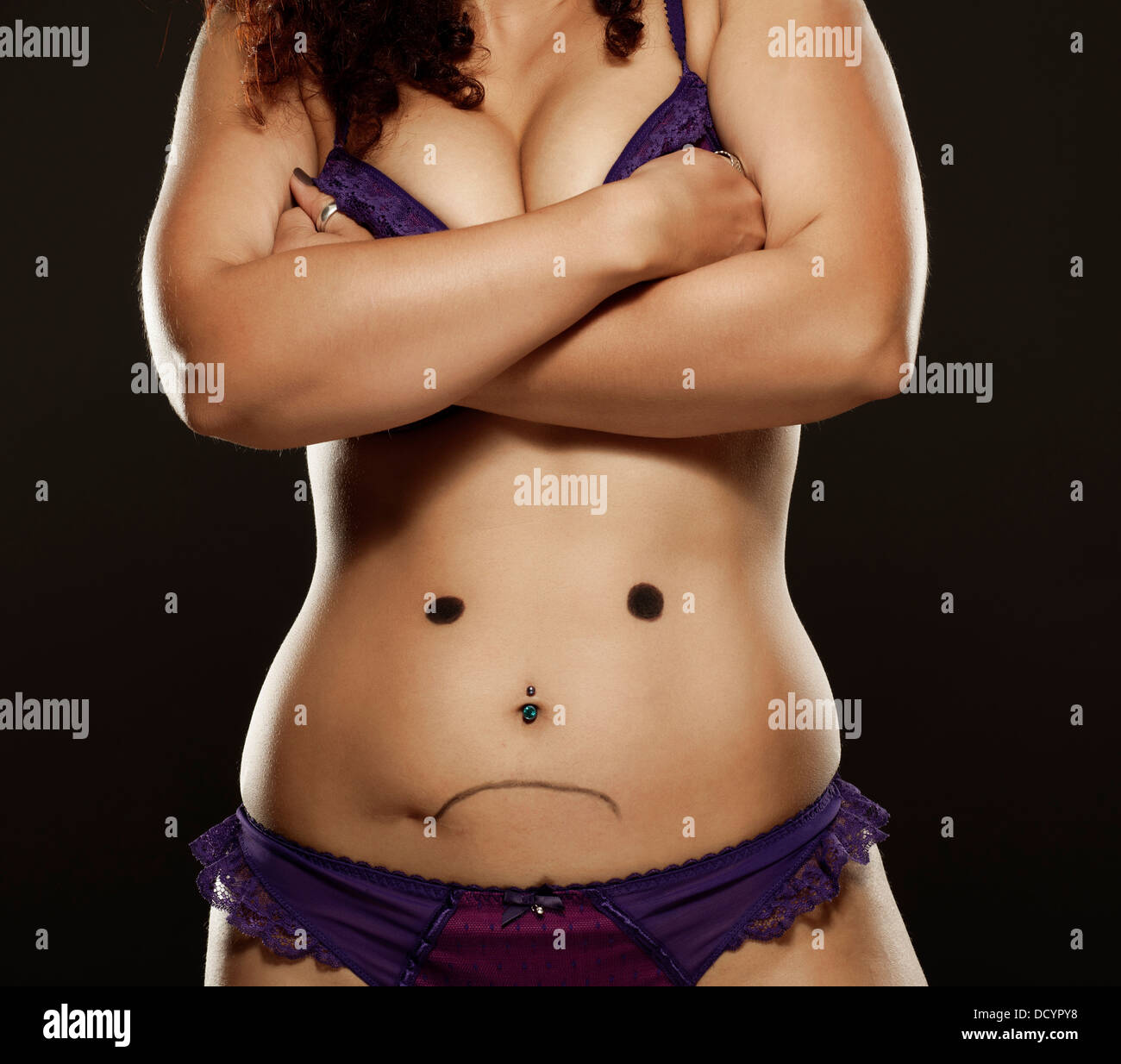Frau mit Zeichnung der unglückliche Gesicht auf Magen Stockfoto