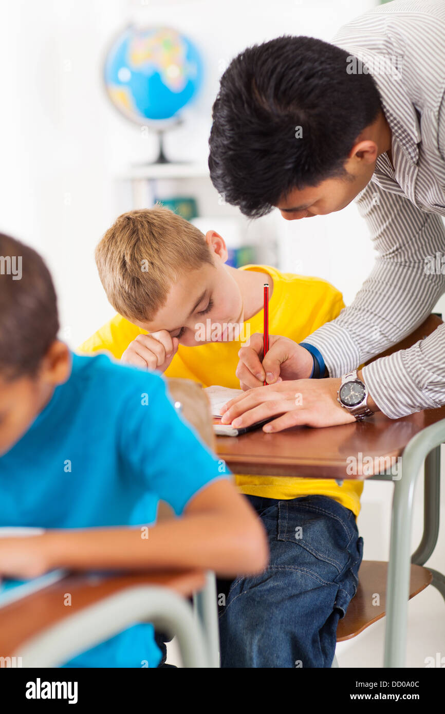 fürsorgliche Lehrer helfen Grundschule Schüler im Klassenzimmer Stockfoto