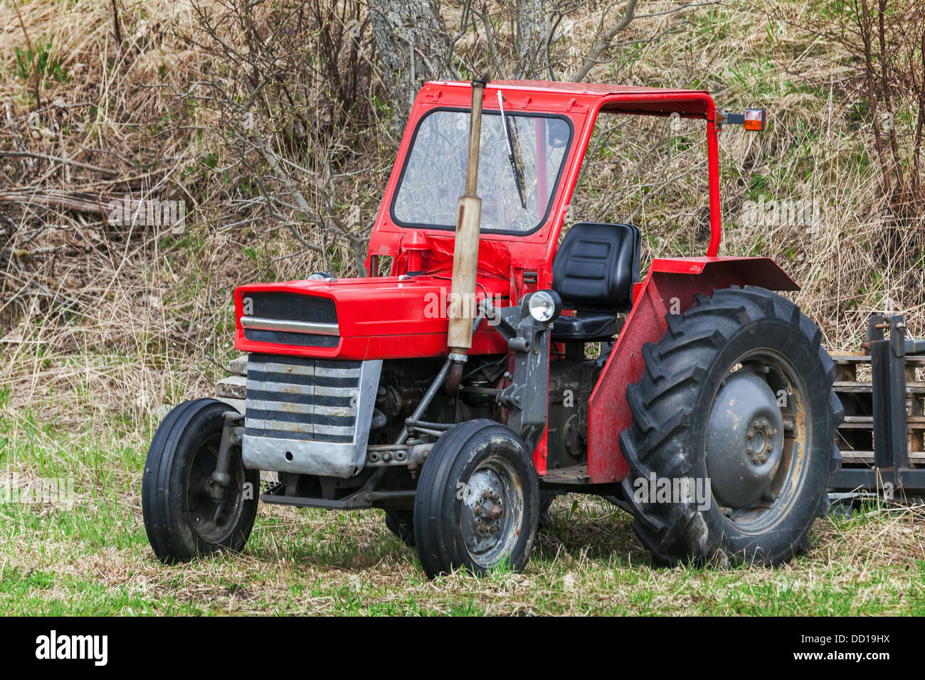 Kleiner roter Traktor steht auf Rasen in Norwegen Stockfoto