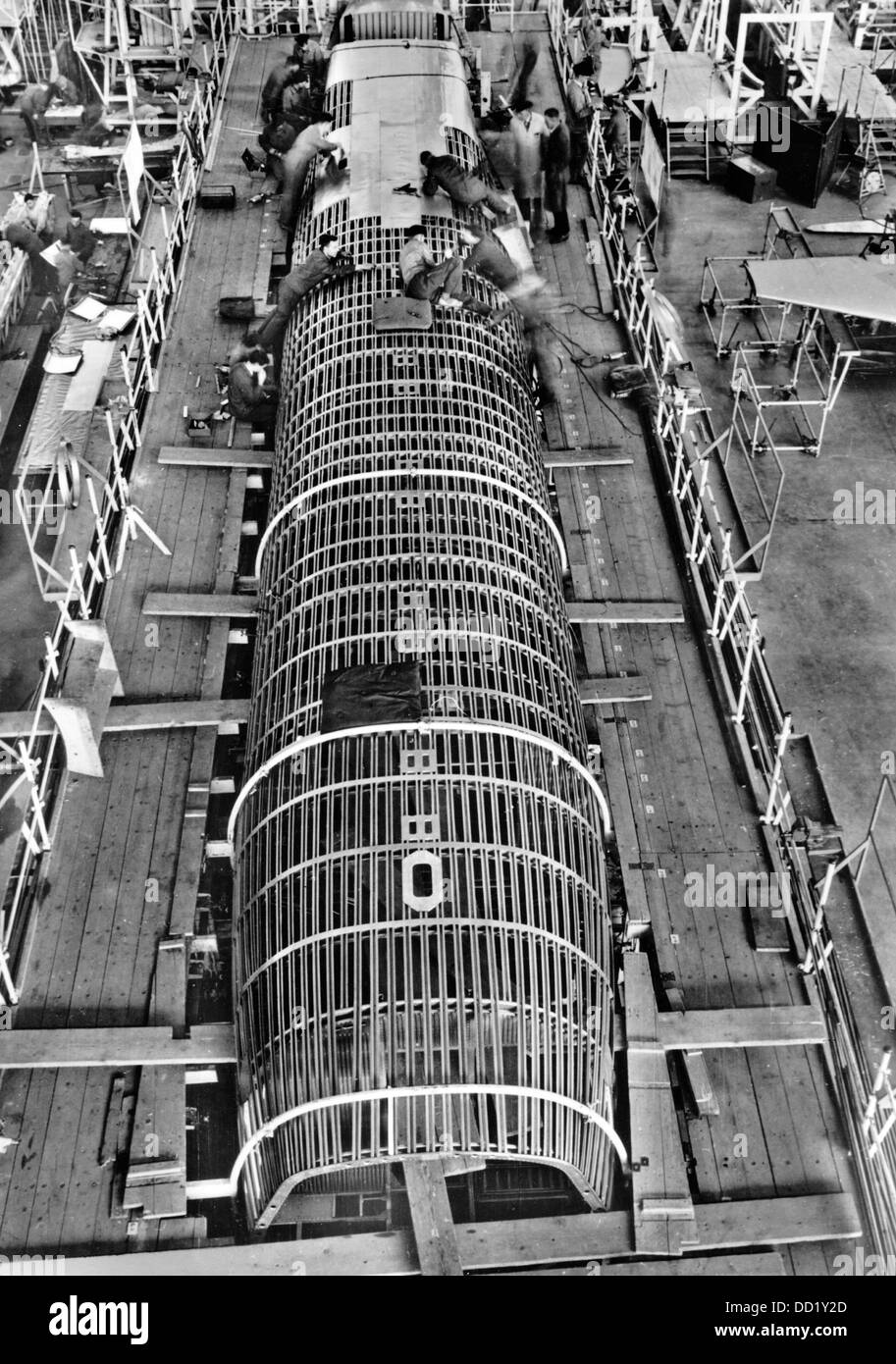 Die Mechanik wird bei der Montage eines Junkers-Ju 90 in den Junkers Flugzeug- und Motorenwerken in Dessau zwischen 1927 und 1939 abgebildet. Die Junkers Flugzeug- und Motorenwerke AG (Junkers Aircraft and Motor Manufacturing AG) war einer der führenden Hersteller der Verteidigungsindustrie im Dritten Reich. Die Nazi-Propaganda! Auf der Rückseite des Bildes steht: "Die Konstruktion des Körpers der Junkers-Ju 90. Die Befestigung der Außenhaut, die aus Duraluminium besteht und durch Nieten am Körper befestigt ist, hat bereits am Heck begonnen.“ Fotoarchiv für Zeitgeschichte Stockfoto