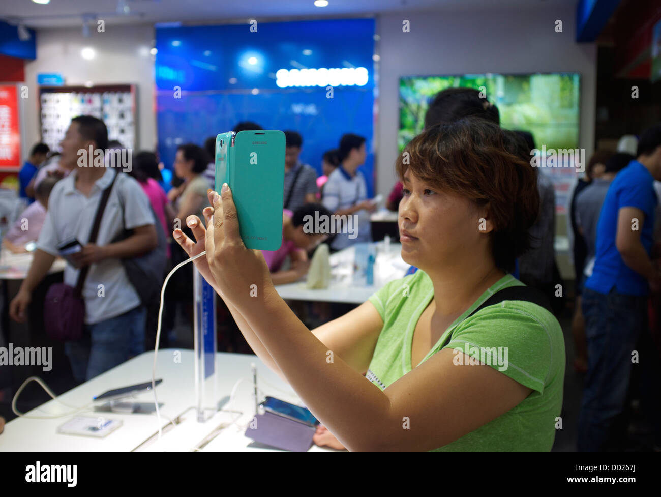 Eine Frau versucht Samsung Galaxy Produkte im Gome Elektrogeräte Store in Peking, China. 2013 Stockfoto
