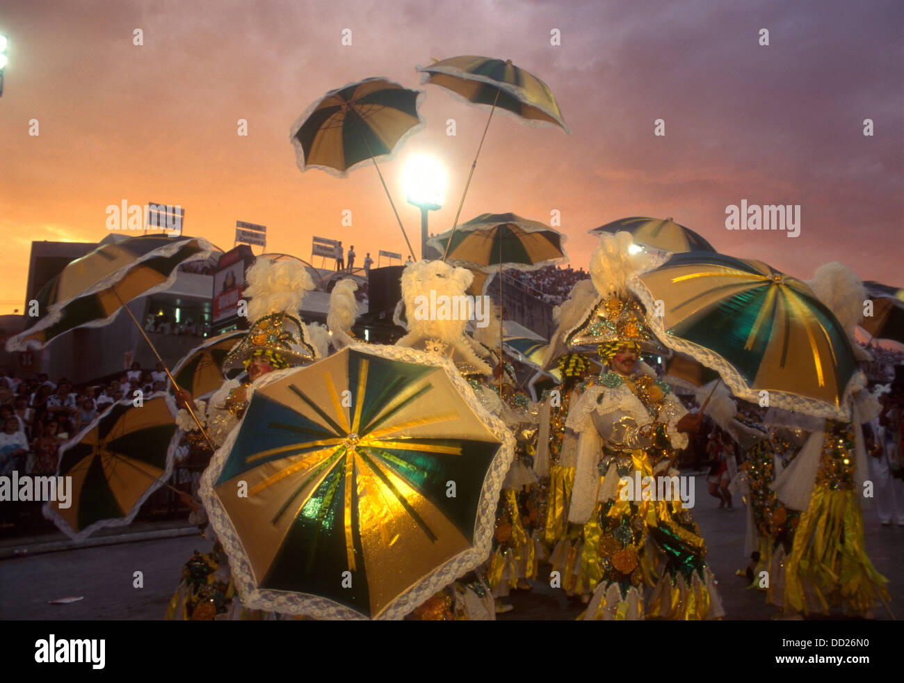 Rio De Janeiro Karneval Brasilien bunte Kostüme Sonnenschirme. Sonnenaufgang im Samba Schulen Parade im Sambódromo Stockfoto