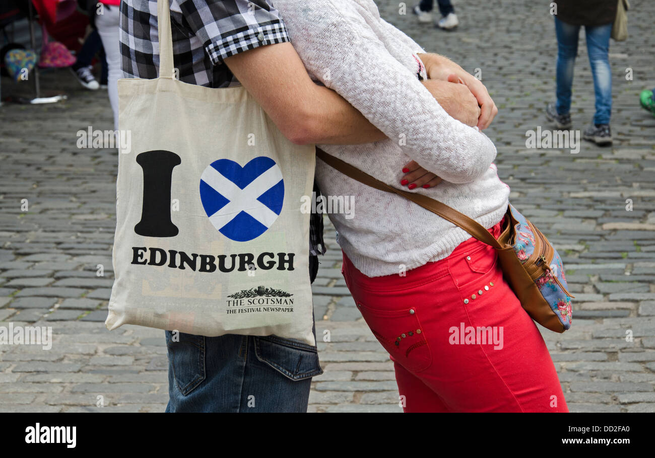 Ein paar stehen auf einer gepflasterten Straße in Edinburghs Altstadt mit I Heart Edinburgh auf eine Tasche. Stockfoto