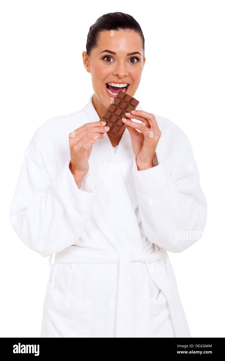 glückliche junge Frau, die Schokolade zu essen, im Pyjama Stockfoto