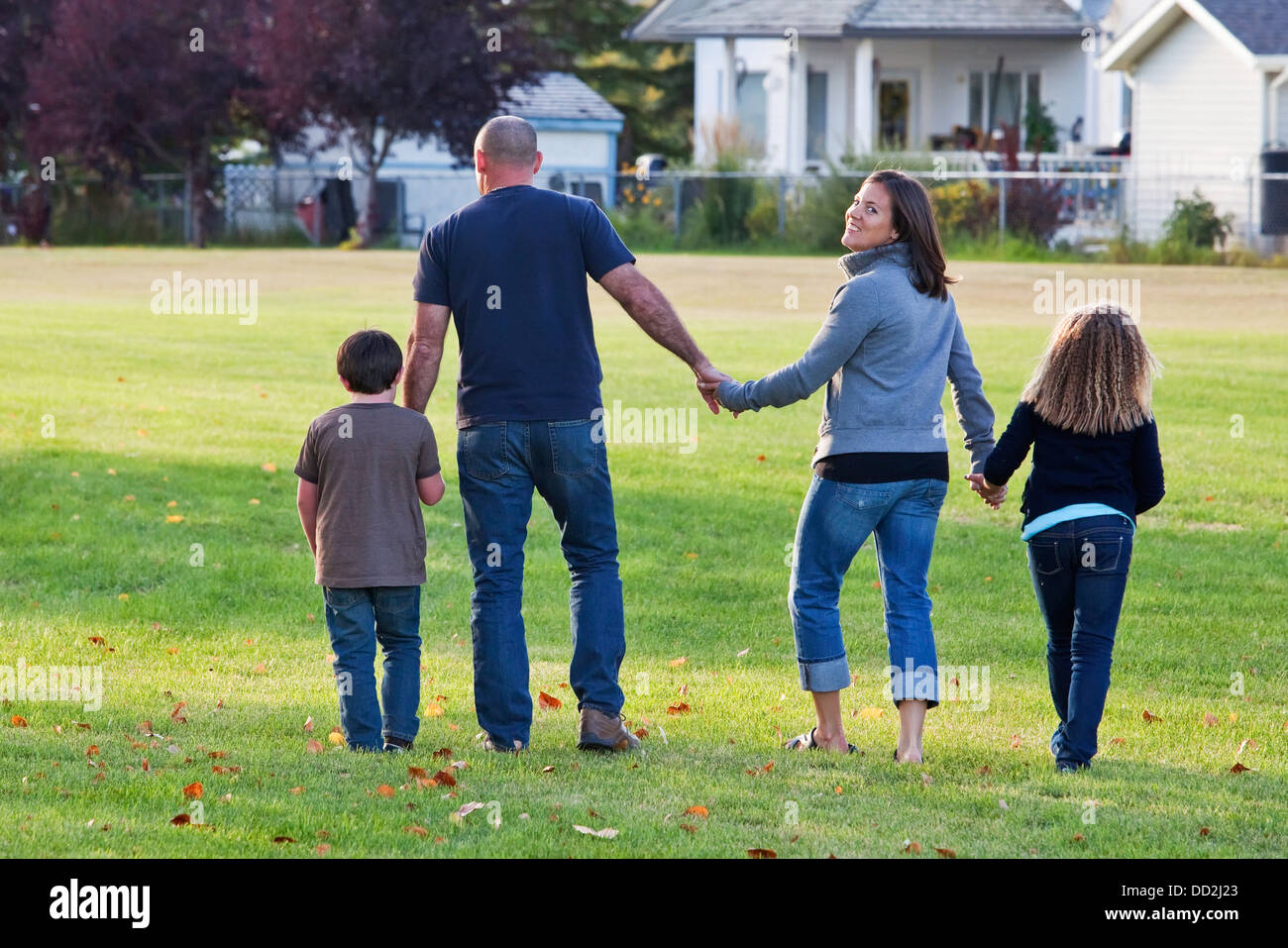 Familie gehen zusammen In einem Park und Mutter Lächeln auf den Lippen; Beaumont, Alberta, Kanada Stockfoto