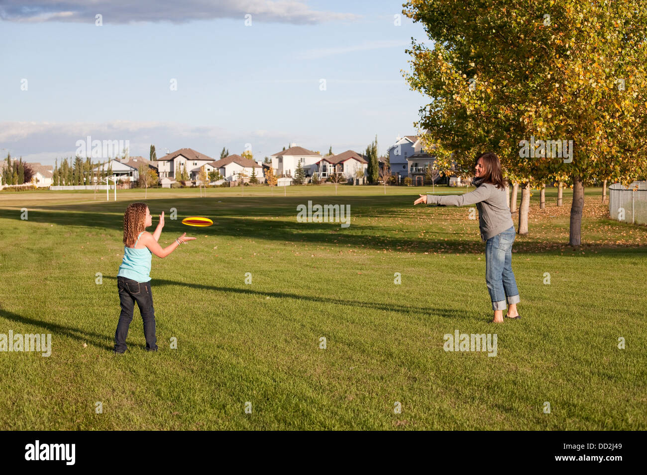 Mutter warf Flying Disc Tochter In einem Park; Beaumont, Alberta, Kanada Stockfoto