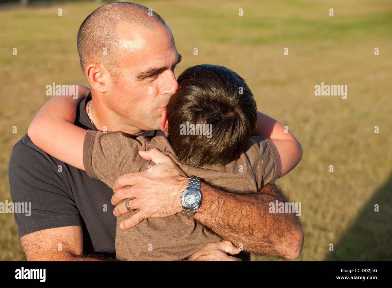 Vater umarmt seinen Sohn In einem Park; Beaumont, Alberta, Kanada Stockfoto