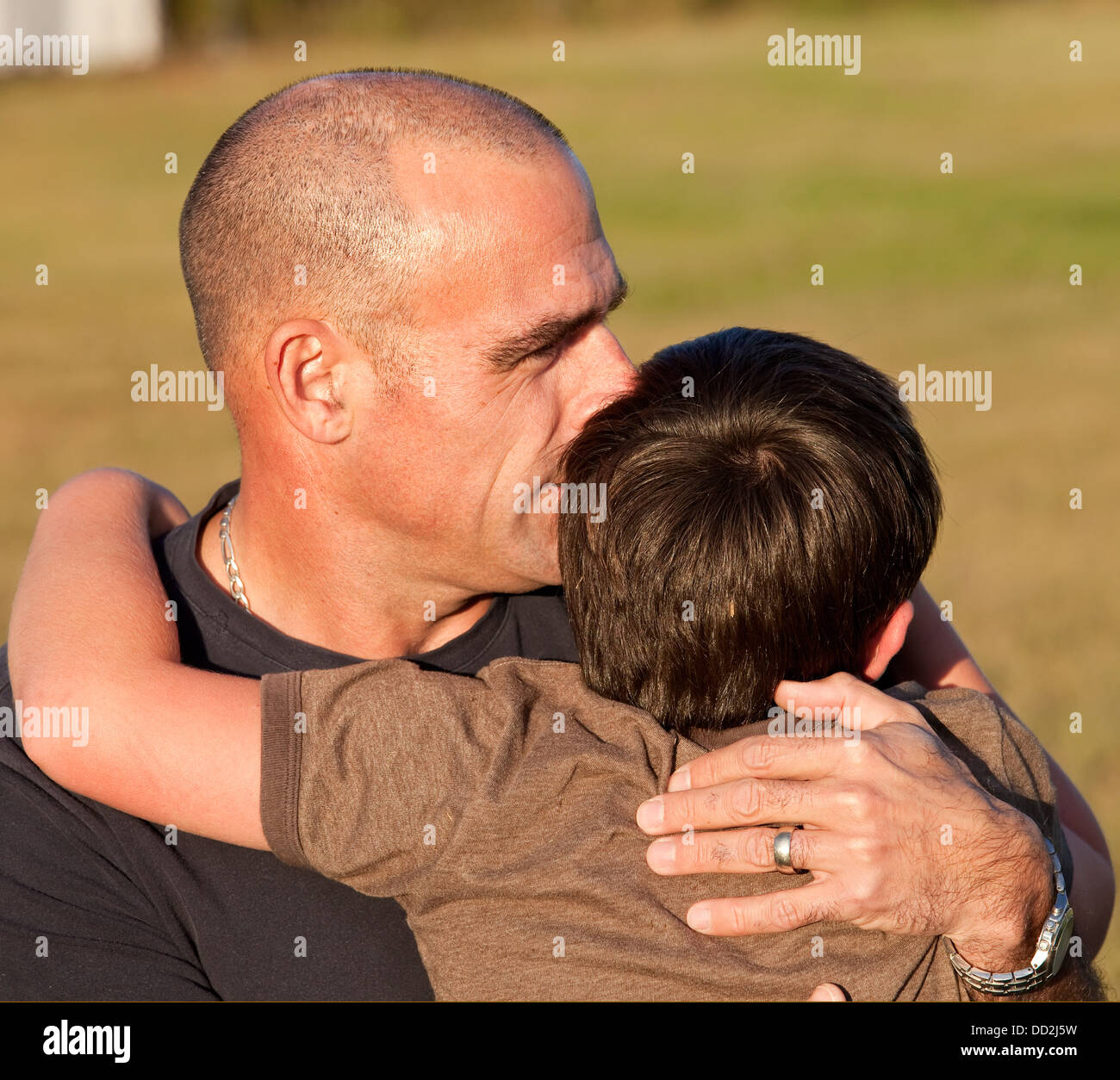 Vater umarmt seinen Sohn In einem Park; Beaumont, Alberta, Kanada Stockfoto
