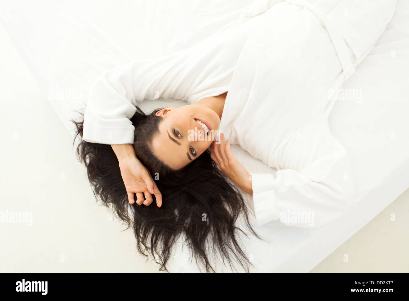 Draufsicht der schönen Frau auf Bett liegend mit Haar verteilt Stockfoto