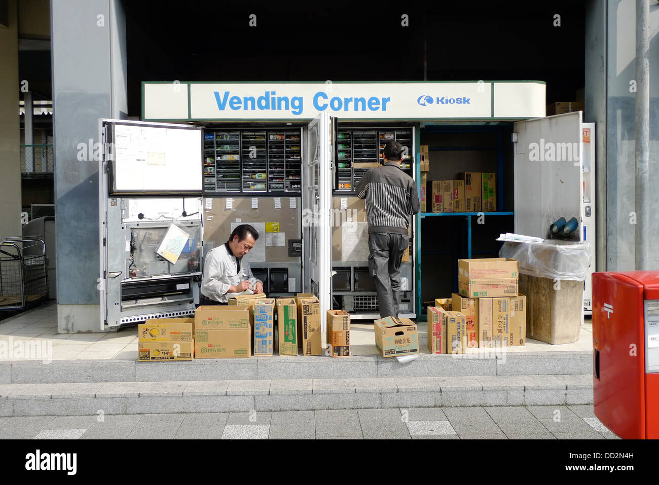 Zwei Arbeiter füllt sich ein paar Automaten in Kyoto, Japan. Stockfoto