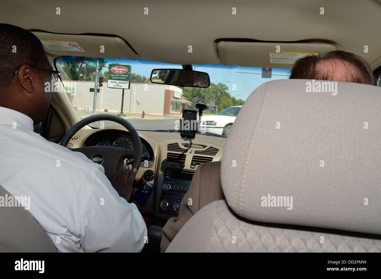 Zwei männliche Bewährungshelfer im Fahrzeug auf dem Weg zu einen Jugendstraftäter an seinem Arbeitsplatz gerecht zu werden. Stockfoto