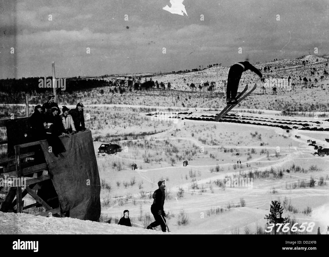 Ein professioneller Skifahrer führt einen Stunt aus der Luft durch und zeigt sein Können und seine Leichtathletik in einem Wettkampf-Skifahren. Das Bild erfasst den Skier mitten in der Luft und demonstriert die Präzision und Kontrolle, die für solche Leistungen erforderlich ist. Stockfoto