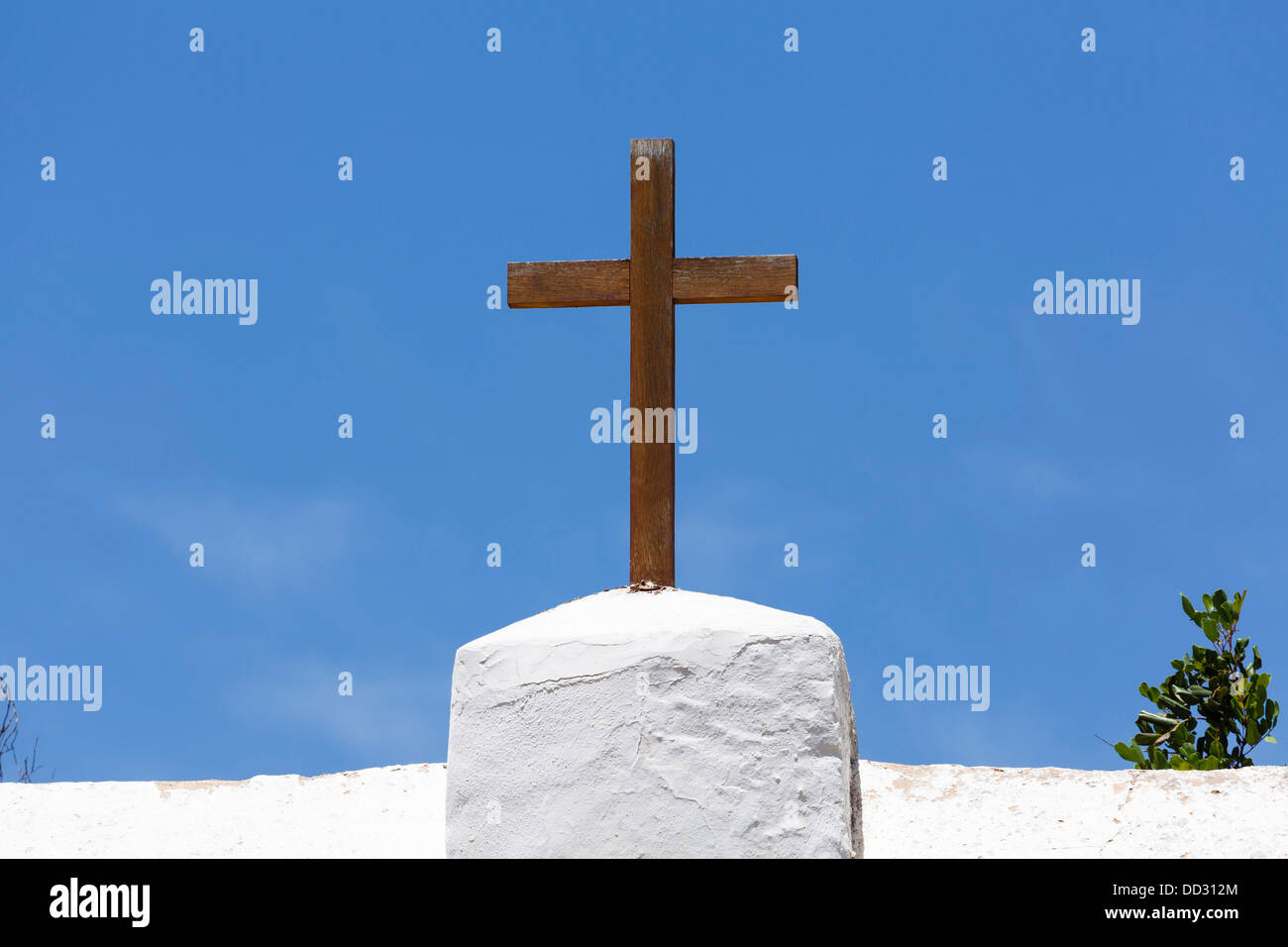 Holzkreuz auf eine weiße Kirche vor einem blauen Himmel in Spanien Stockfoto