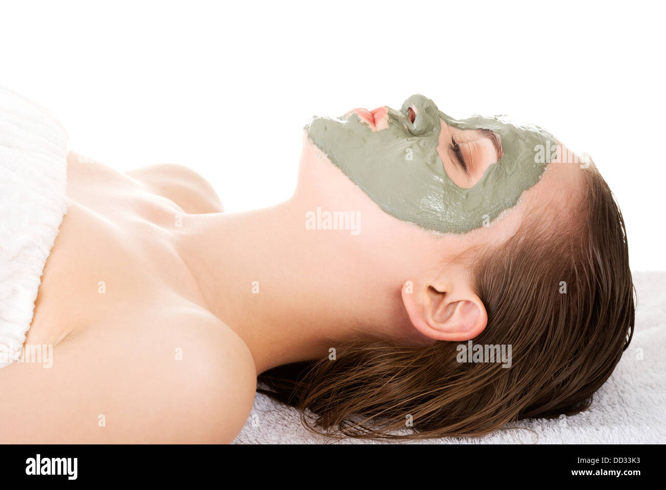 Beauty-Behandlung im Wellness-Salon. Frau mit Gesichts Tonerdemaske. Isoliert auf weiss Stockfoto