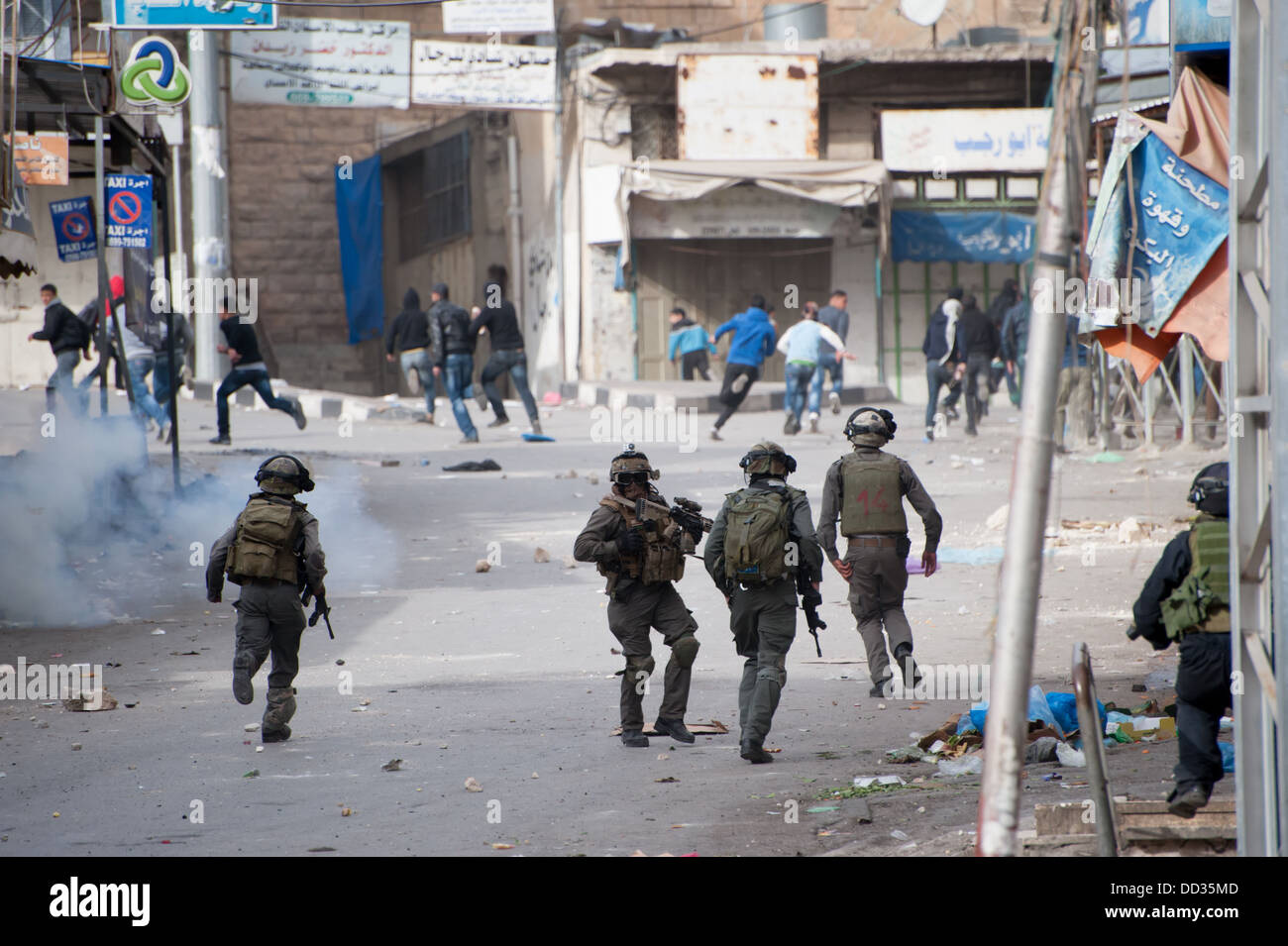 Israelische Truppen hinterher einen Protest in der Westbank-Stadt Hebron Palästinenser bei Zusammenstößen. Stockfoto