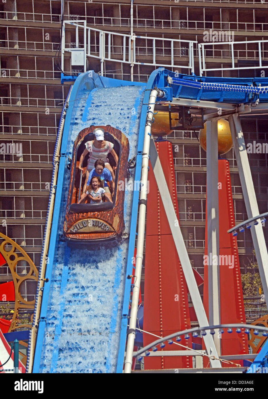 Mit Wohnhäusern im Hintergrund reitet eine Familie Wild River Attraktion im Luna Park auf Coney Island, Brooklyn New York Stockfoto