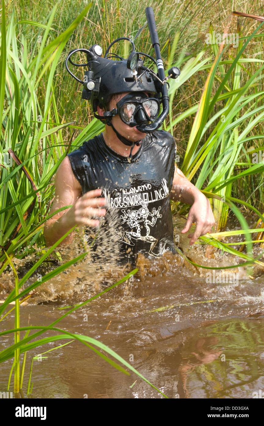 Llanwrtyd Wells, UK.25th August 2013. Australische Komiker & TV Host Amos Gill 22, tourt die Welt mit ABC-TV machen Kinder Dokumentarfilm über ungewöhnliche Ereignisse. Der jährlichen Weltmeisterschaft Bogsnorkelling findet jeden August Bank Holiday im berühmten Wän Rhydd Bog.in die Waliser der Cambrian Mountains in der Nähe von der kleinsten Stadt in Großbritannien bekannt für seine skurrilen Sport. Die Idee entstand im Jahr 1985 durch Vermieter Gordon Green The Neuadd Arms Pub Llanwrtyd Wells auf die Karte setzen. Weltmeister ist Andrew Holmes mit der Zeit der 84secs in 2011.Photo:Graham M. Lawrence/Alamy Live News Stockfoto