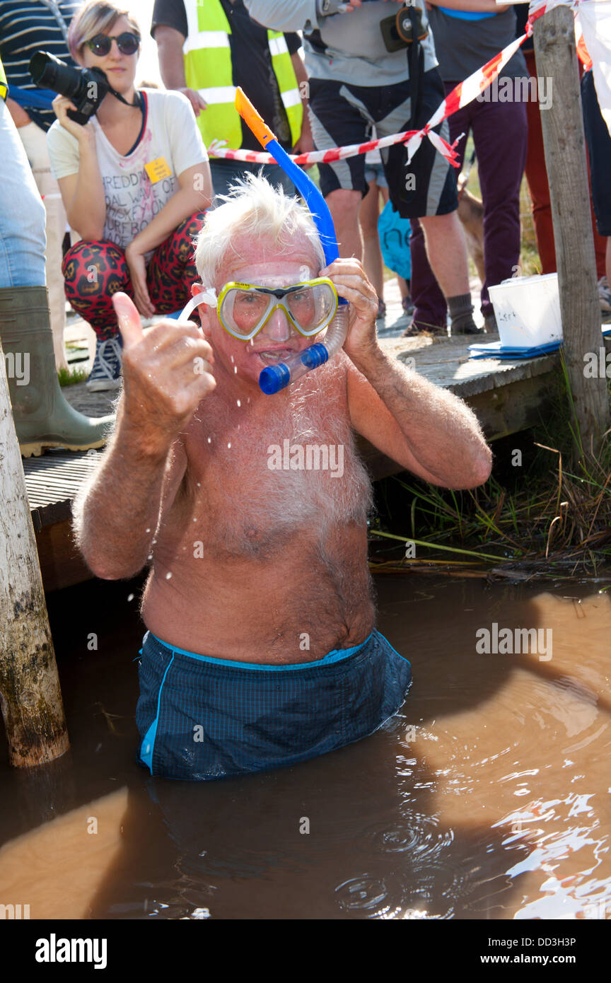 Llanwrtyd Wells, UK. 25. August 2013. Bogsnokelling Gründer Gordon Green 79, braucht, um das Moor. Der jährlichen Weltmeisterschaft Bogsnorkelling findet jeden August Bank Holiday im berühmten Wän Rhydd Bog.in die Waliser der Cambrian Mountains in der Nähe von der kleinsten Stadt in Großbritannien bekannt für seine skurrilen Sport. Die Idee entstand im Jahr 1985 durch Vermieter Gordon Green The Neuadd Arms Pub Llanwrtyd Wells auf die Karte setzen. Weltmeister ist Andrew Holmes mit einer Zeit von 84secs im Jahr 2011. Foto: Graham M. Lawrence/Alamy Live-Nachrichten. Stockfoto