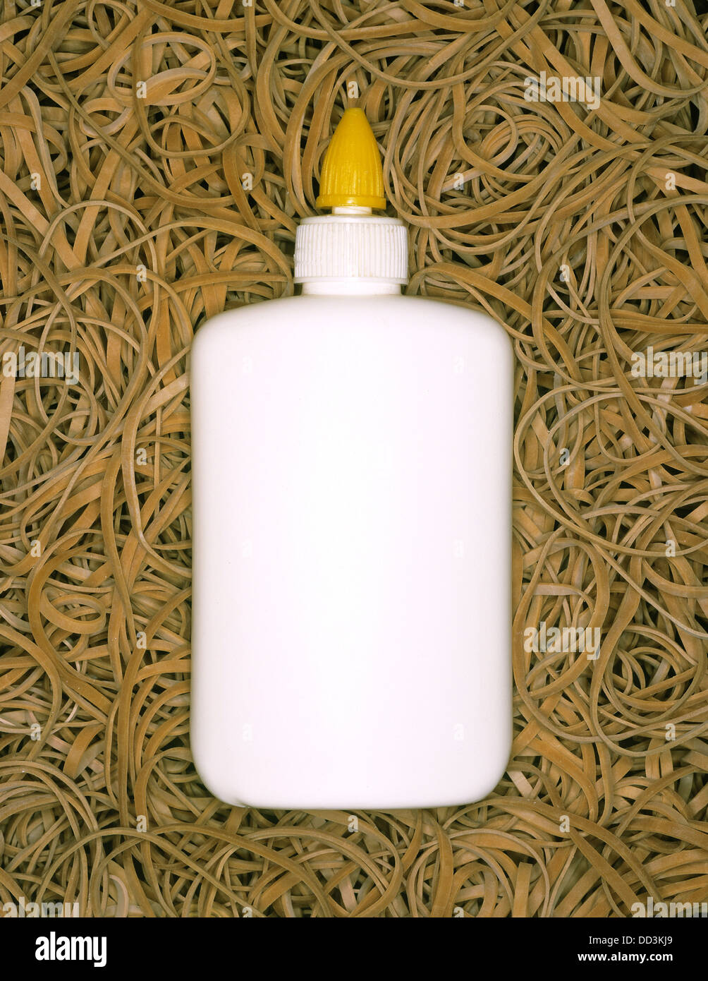 Eine Flasche von Weißleim auf einem Hintergrund von Gummibändern. Stockfoto