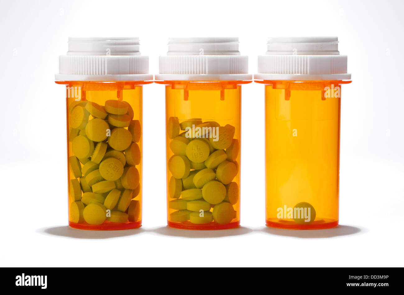 Drei verschreibungspflichtige Flaschen drei unterschiedlichen Mengen an Tabletten im Inneren. Weißen Hintergrund. Stockfoto