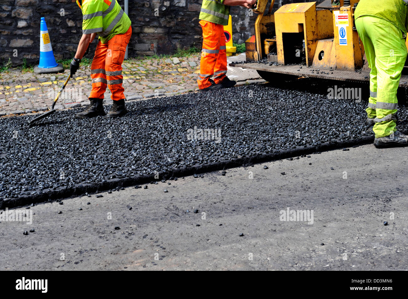 Arbeiter, die Verbreitung von Asphalt während Straße Oberflächenersatz Stockfoto