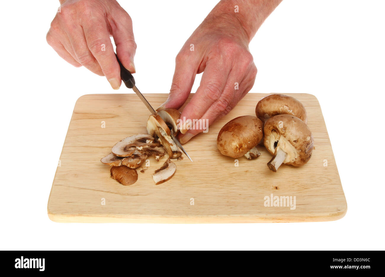 Nahaufnahme von Hand hacken Pilze auf einem Holzbrett isoliert gegen weiß Stockfoto