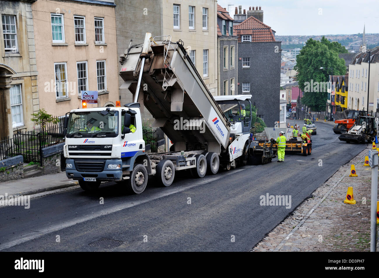 Straßenarbeiten, Kipper LKW-Verladung Asphalt Verbreitung Maschine für Straße Oberflächenersatz, Bristol, UK Stockfoto