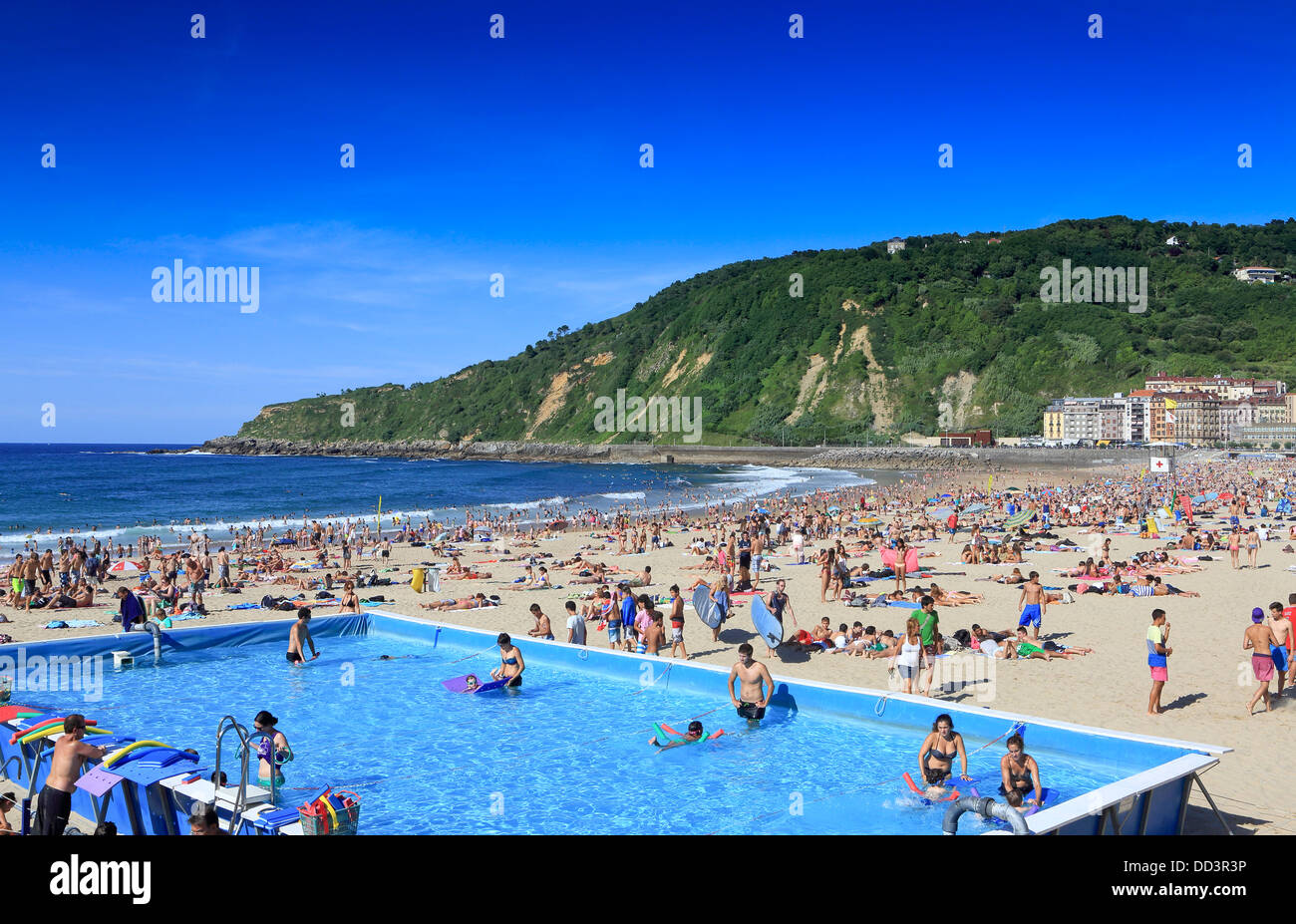 Schwimmbad im Einsatz auf einem überfüllten Gros Strand während des Sommers in San Sebastian, Spanien Stockfoto