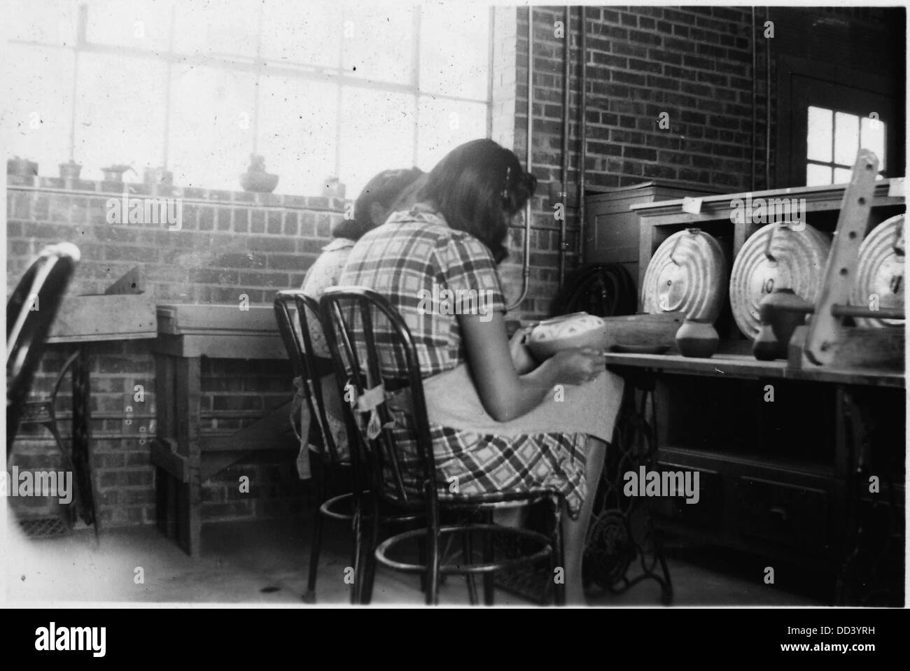 Frauen werden gesehen, wie sie Tonwaren, ein traditionelles Handwerk in verschiedenen Kulturen, mit Pigmenten versehen, die die künstlerischen und funktionellen Aspekte der Keramikherstellung widerspiegeln. Stockfoto