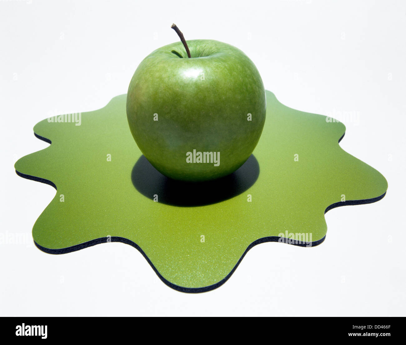 Ein grüner Apfel auf einem grünen organische Form. Weißem Hintergrund Stockfoto