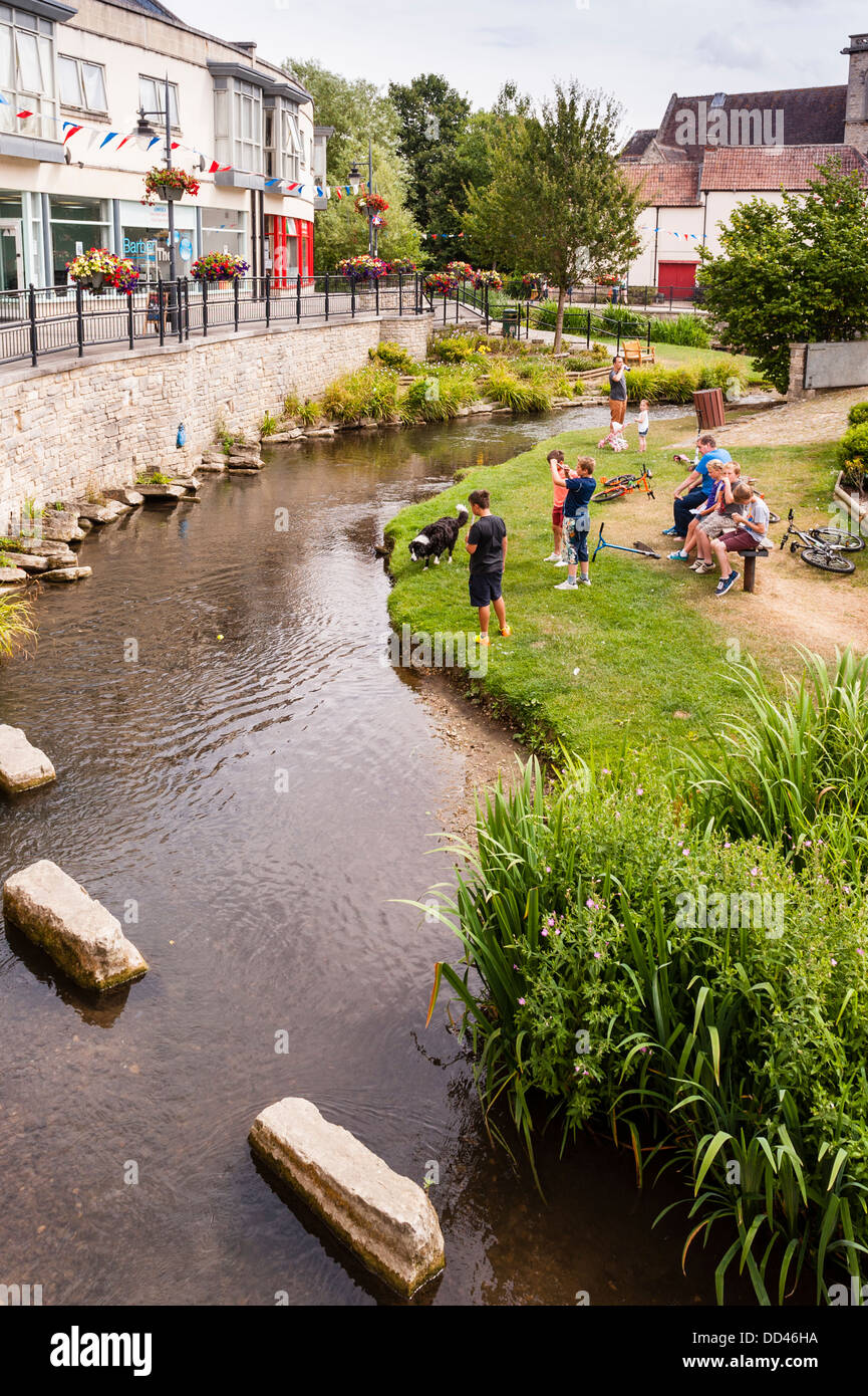 Menschen spielen in einem Stream in Calne, Wiltshire, England, Großbritannien, Uk Stockfoto