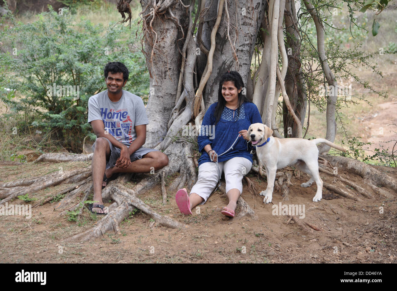 Bruder und Schwester ausruhen mit Haustier unter einem Banyanbaum Stockfoto