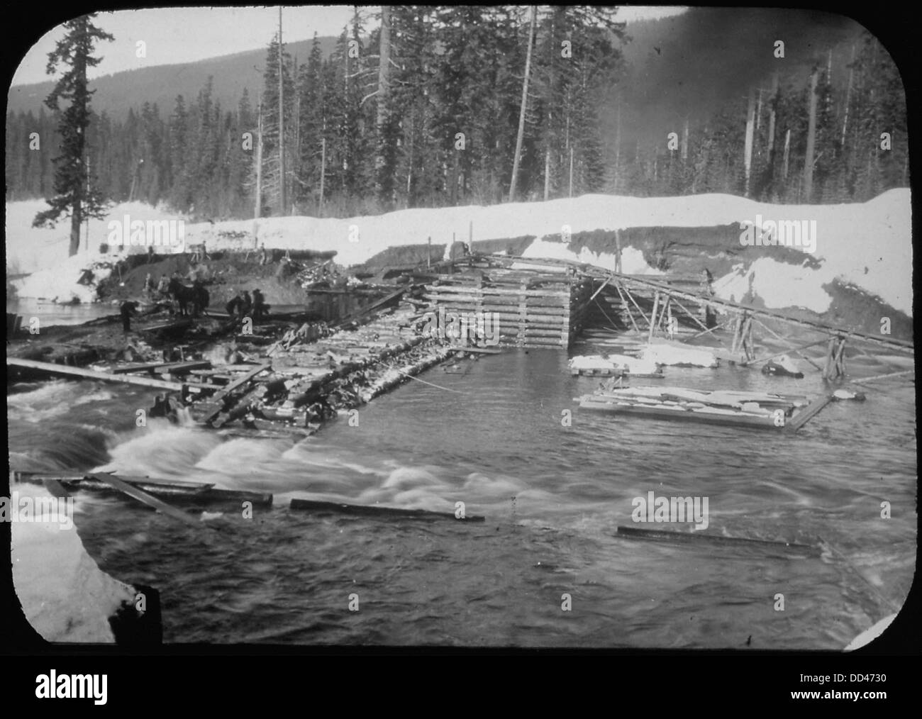 Das Bild zeigt den Abutment Crib Damm am Lake Keechelus, Washington, während eines Frischens, einer Zeit mit erhöhtem Wasserfluss. Das Yakima-Projekt, eine große Wasserwirtschaftsinitiative, zielte auf die Kontrolle der Wasserressourcen in der Region ab. Stockfoto