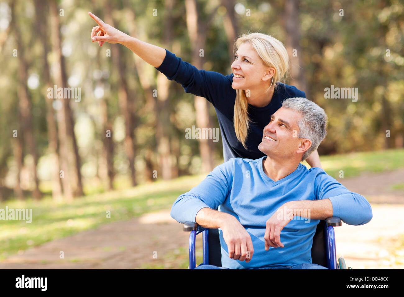 liebevolle Mitte Alter Frau nehmen verletzten Mann für einen Spaziergang im freien Stockfoto