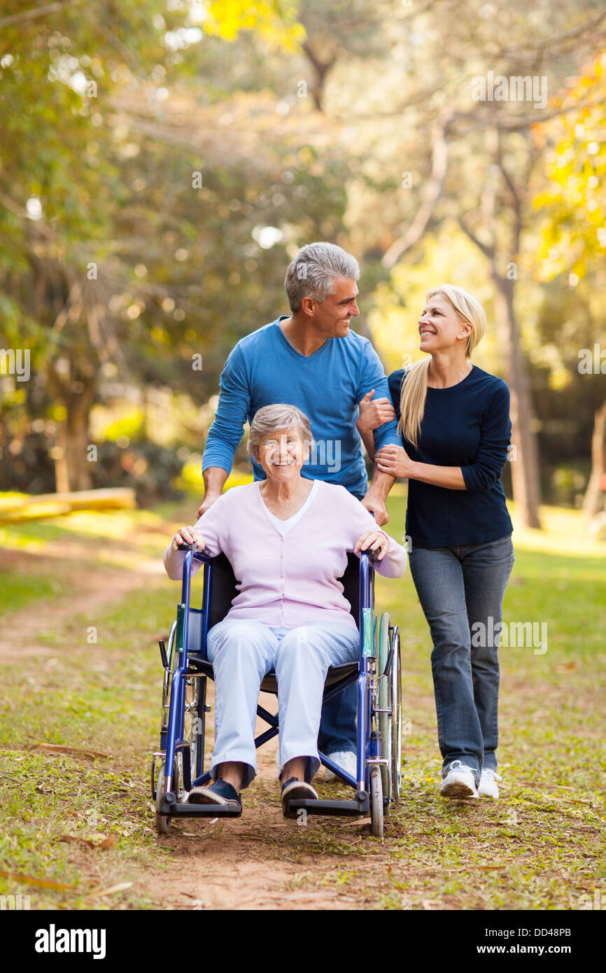 liebevolle mittleren paar Aufnahme deaktiviert Mutter für einen Spaziergang im Freien im Alter von Stockfoto