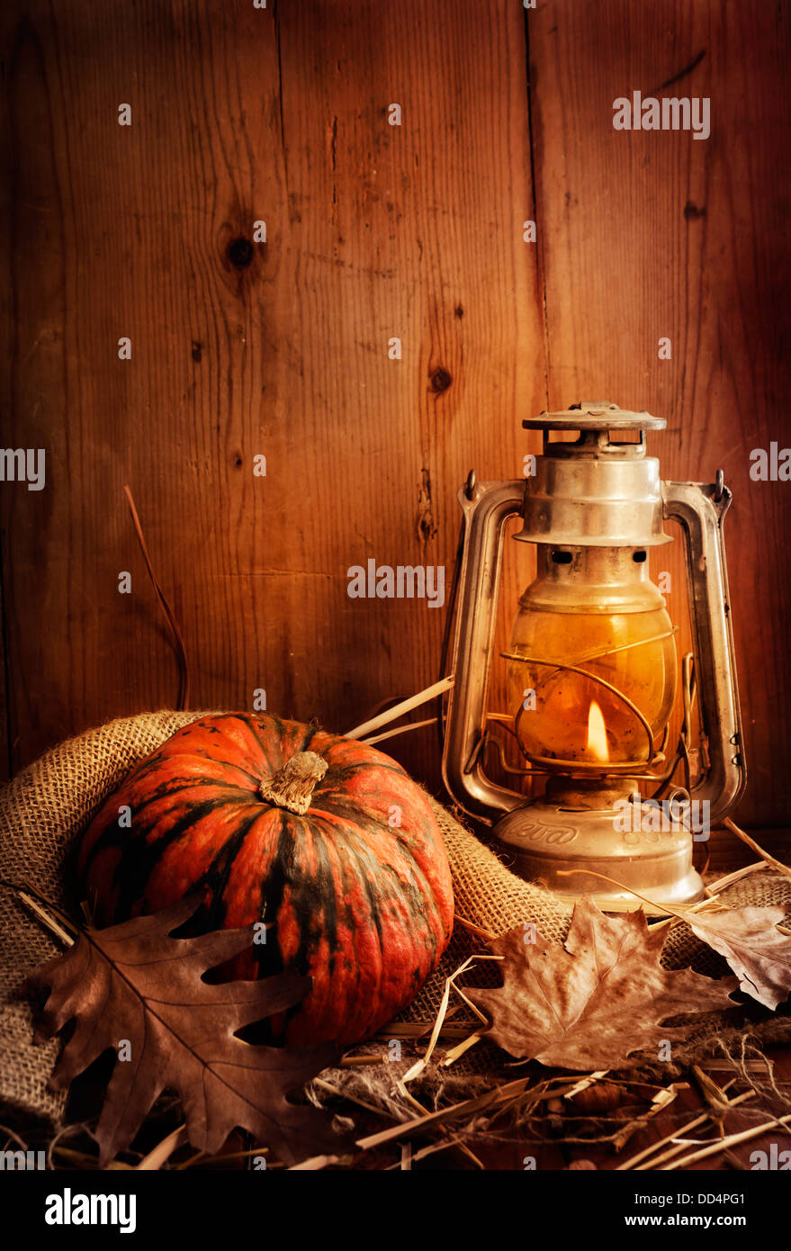 Still-Leben. Kürbis, beleuchtete Laterne und Herbstlaub. Stockfoto