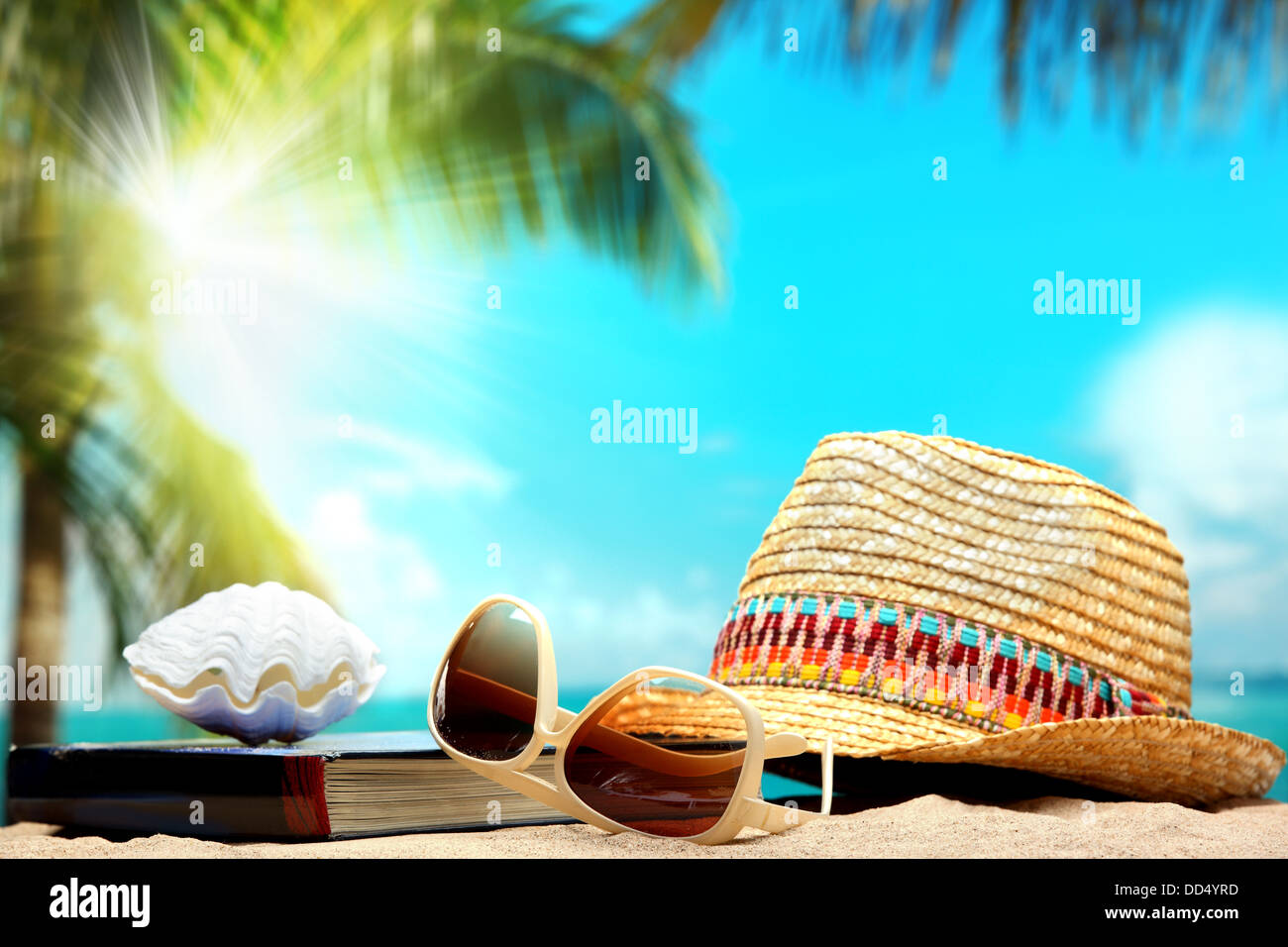 Hut, Brille und Buch am Sand Strand, Strand-Konzept. Stockfoto