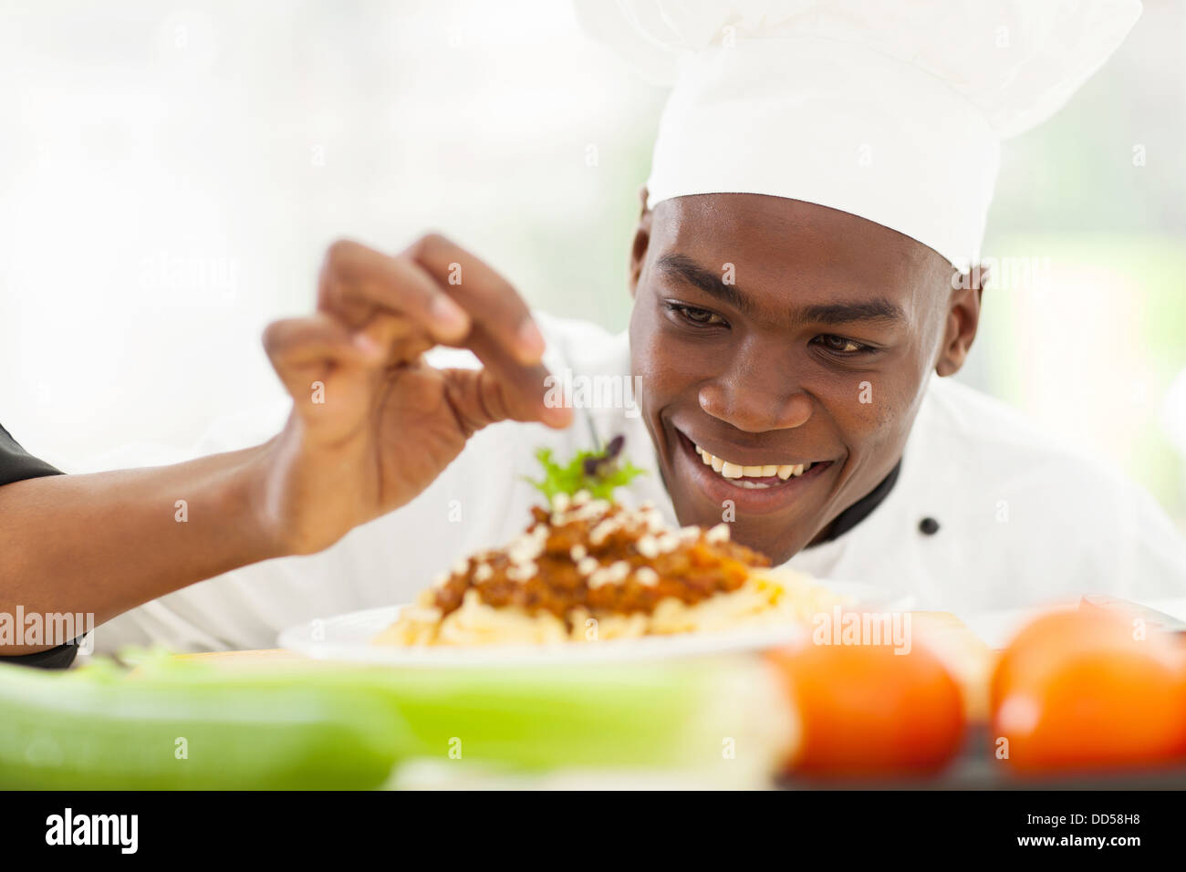 Porträt von Afro amerikanische Chefkoch im Restaurantküche Garnierung Nudelgericht Stockfoto