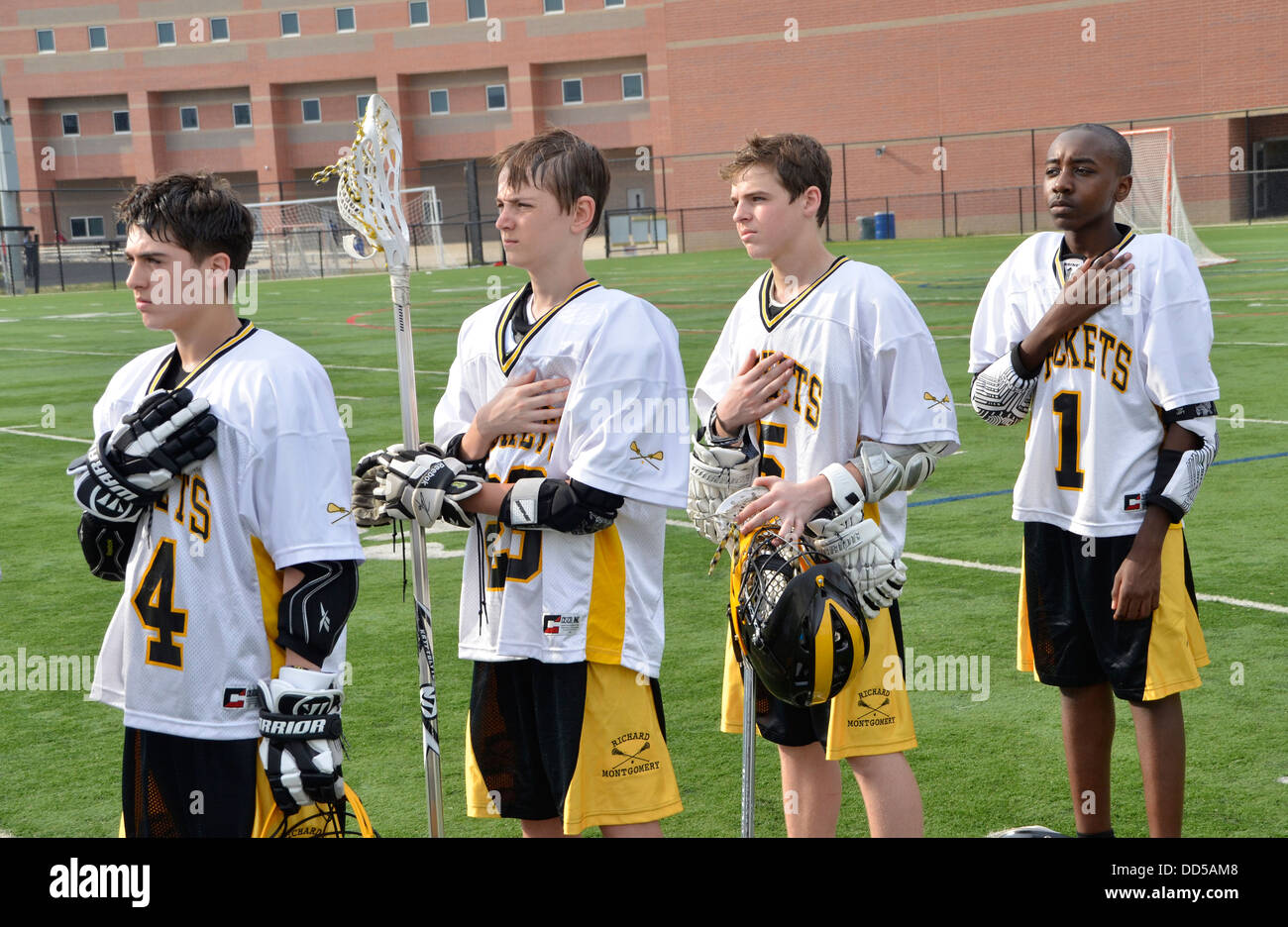 High School-Lacrosse-Spieler stehen stramm für die Nationalhymne Stockfoto