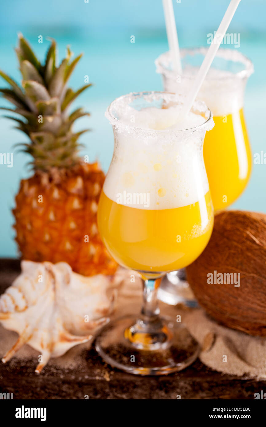 Cocktail aus Ananassaft, Rum, Likör auf Tisch am Himmelshintergrund Stockfoto