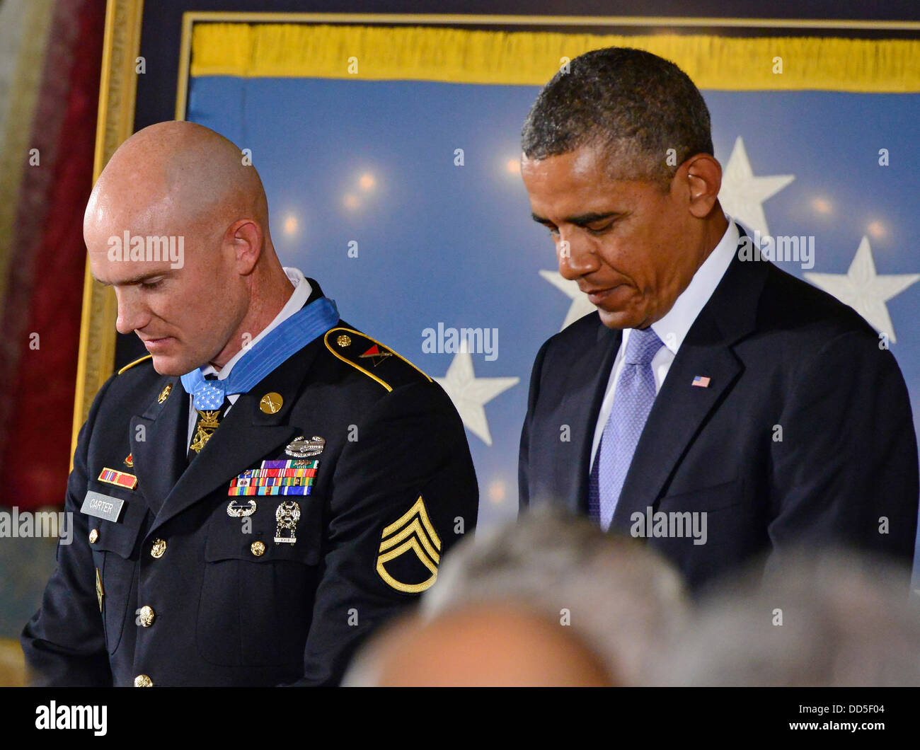 Washington, D.C., USA. 26. August 2013. US-Präsident Barack Obama neigt seinen Kopf im Gebet nach der Vergabe der Medal Of Honor für auffällige Galanterie, Staff Sergeant Ty M. Carter, US Army, während einer Zeremonie im East Room des weißen Hauses in Washington, D.C. USA, 26. August 2013. Staff Sergeant Carter wird für die mutigen Taten während seiner Tätigkeit als Kavallerie Scout mit Bravo Truppe, 3. Staffel, 61. Kavallerieregiment, 4th Brigade Combat Team, 4. US-Infanteriedivision, während der Kampfhandlungen im Kamdesh Bezirk, Nuristan Provinz, Afghanistan am 3. Oktober 2009 geehrt. Personal... Stockfoto