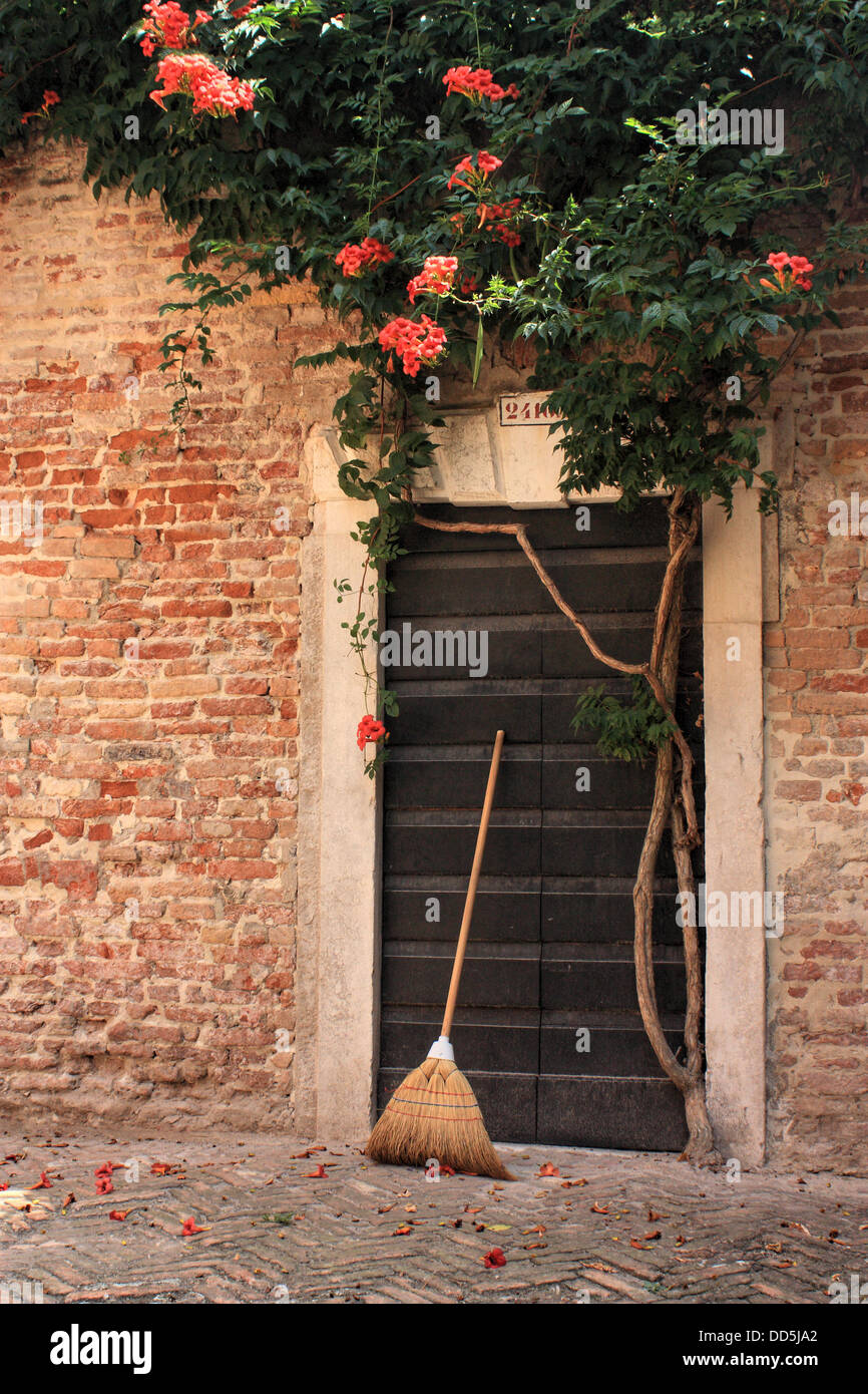 Besen Besen an einen alten Garten Tür in Venedig Stockfoto