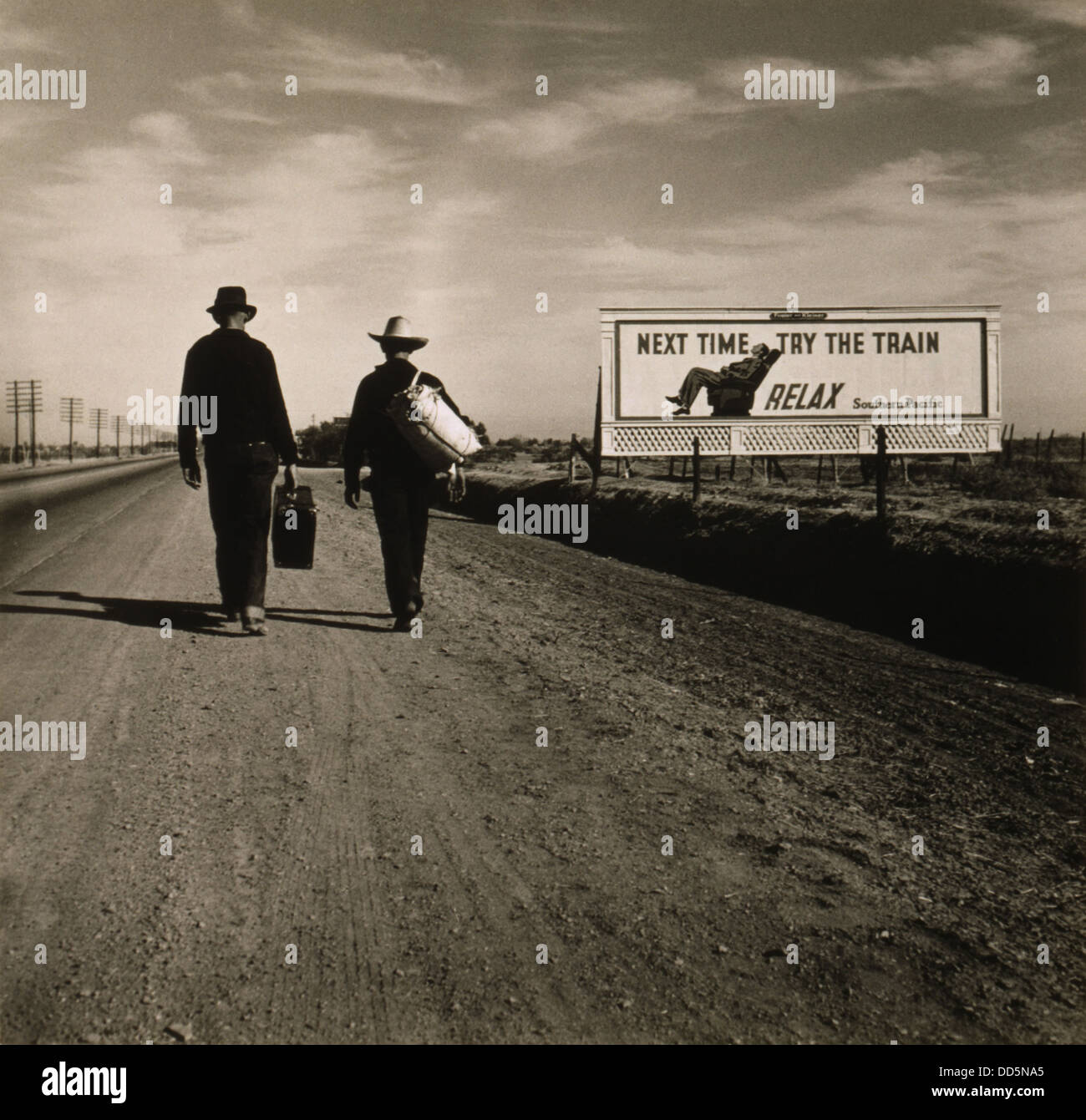 Zwei Männer gehen in Richtung Los Angeles März 1937. Vor ihnen ist eine südliche pazifische Eisenbahn Werbetafel lesen, "das nächste Mal versuchen Stockfoto