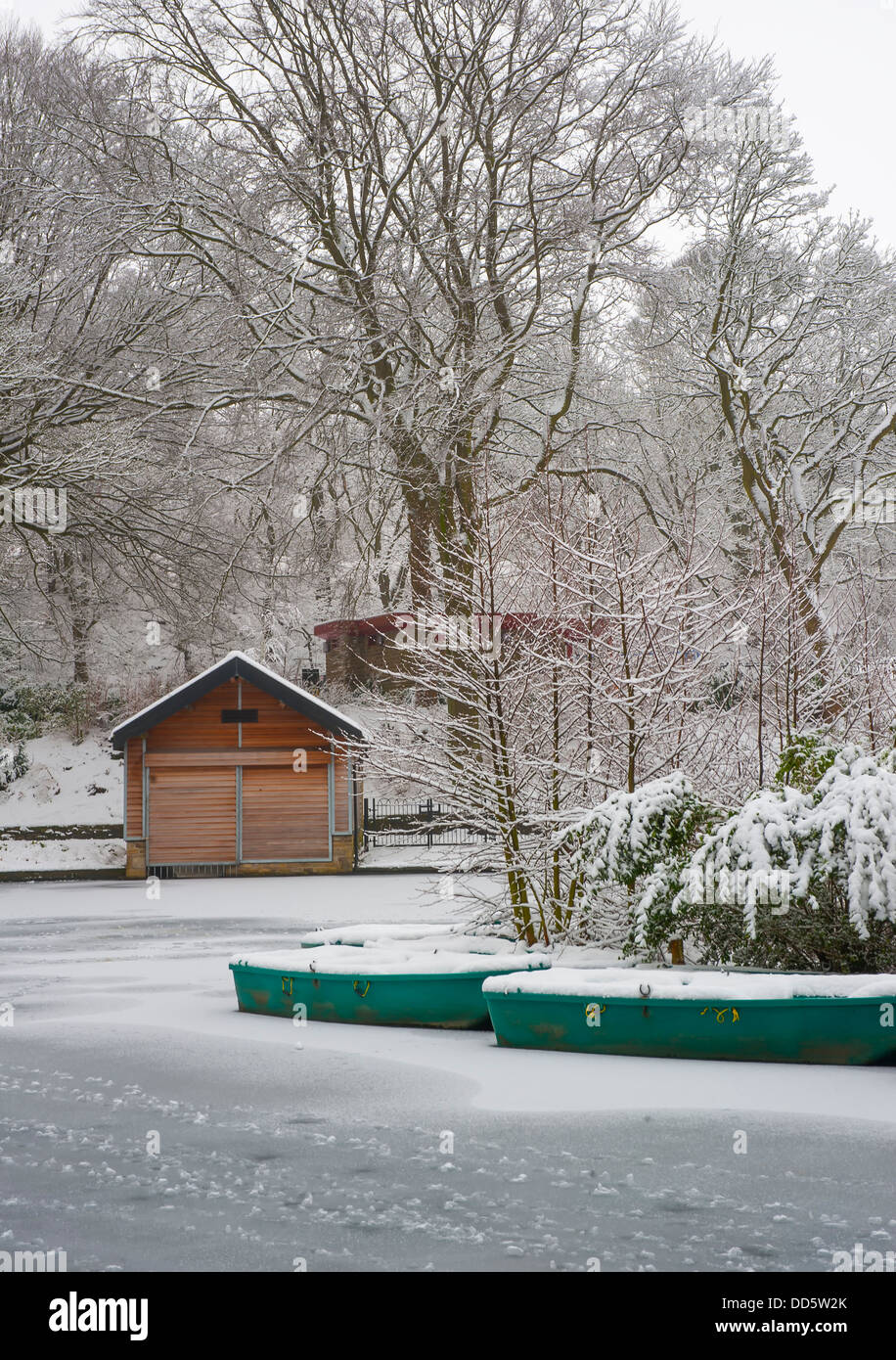 schneebedeckte Ruderboot auf den See mit Booten im SHibden Park in Halifax, Calderdale, West yorkshire Stockfoto