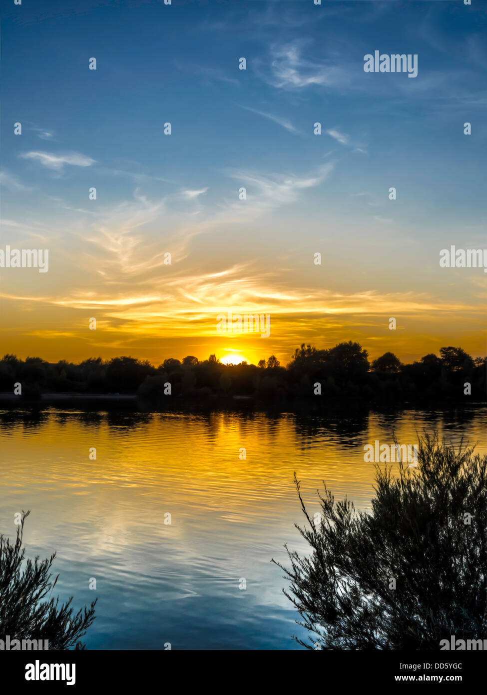 Sonnenuntergang mit blauen und goldenen Farben auf einem See in Deutschland Stockfoto